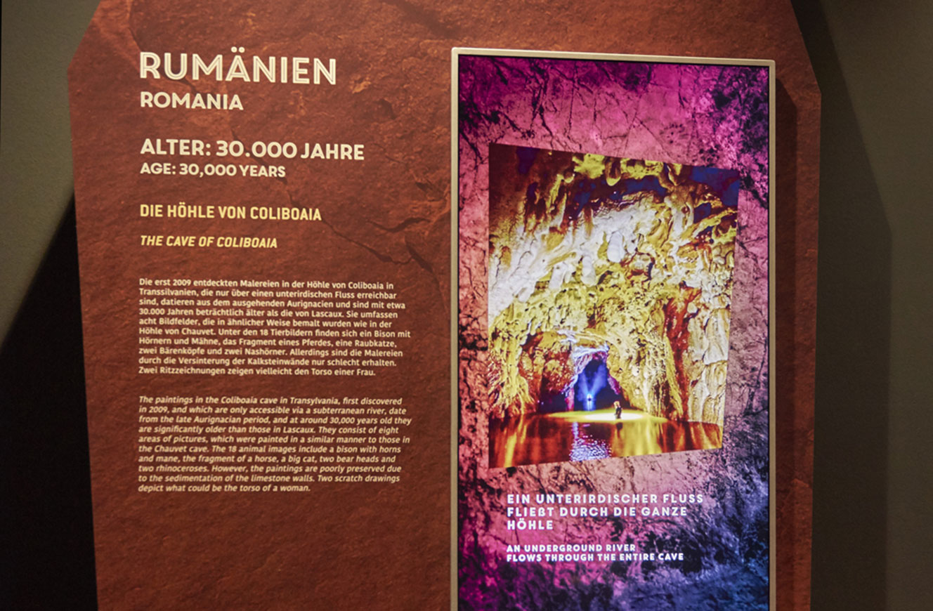 Infotafel zur Höhle von Colibaia in Rumänien mit beleuchtetem Bildschirm und Höhlenaufnahme – Lascaux