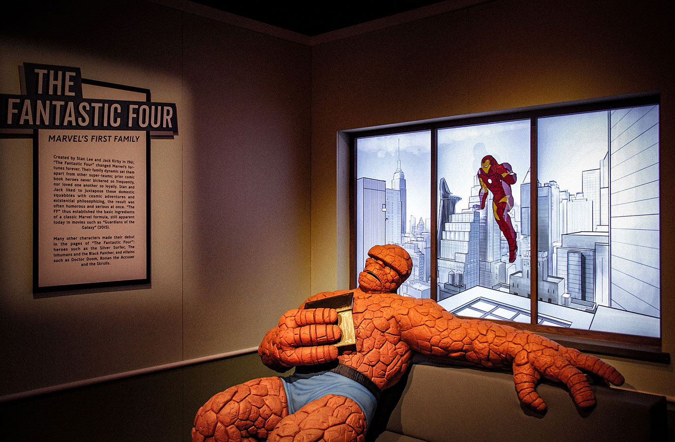 Figur The Thing an einem Fenster, dahinter eine animierte Stadtkulisse mit fliegendem Iron Man – Bereich The Fantastic Four