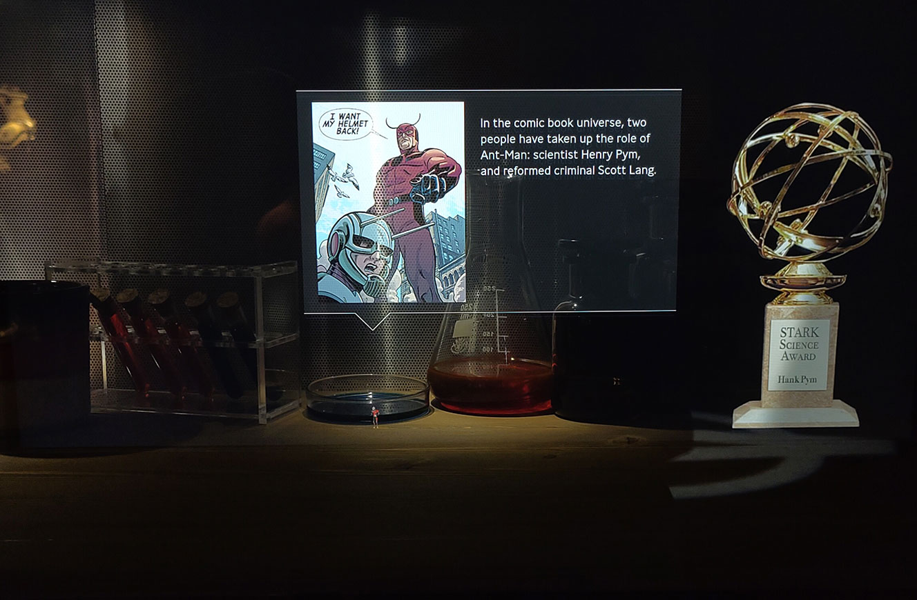 Peppers-Ghost-Installation mit Laborgläsern und dem Stark Science Award, darüber ein scheinbar schwebender Comicausschnitt zur Figur Ant-Man