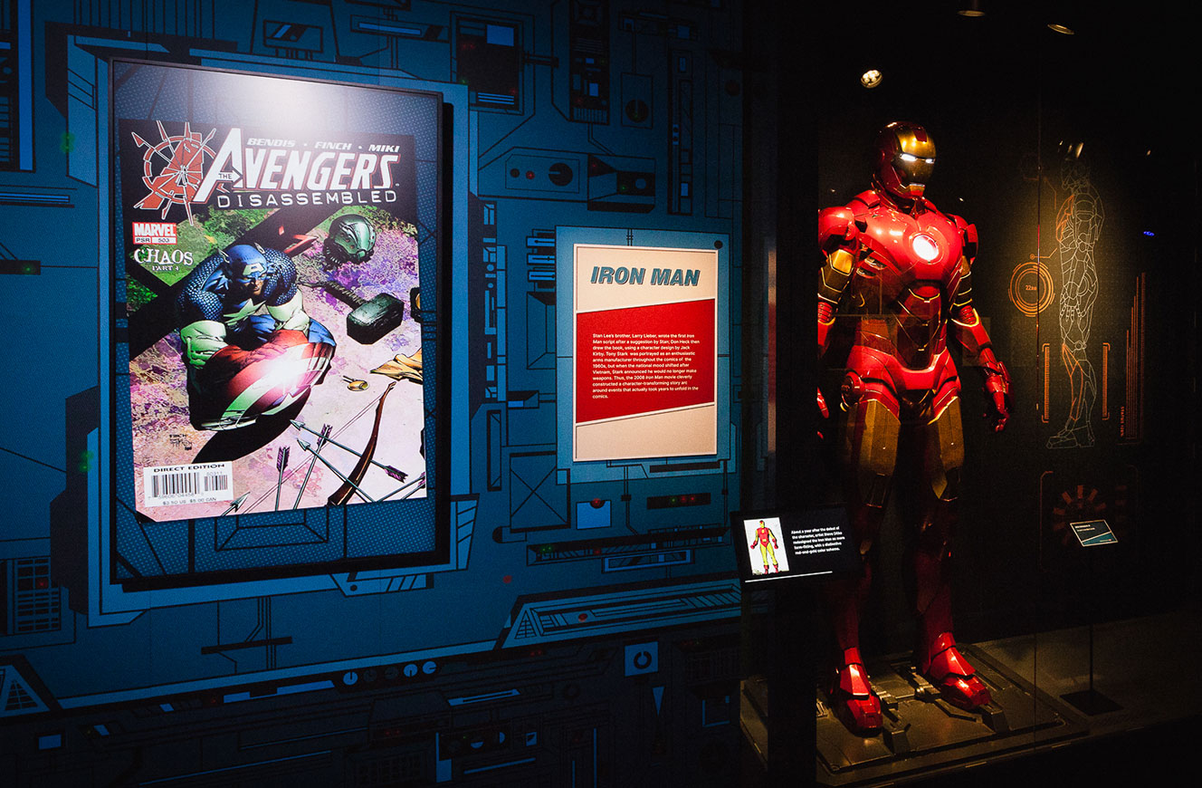 Iron-Man-Bereich der Marvel-Ausstellung mit Rüstungsexponat und Slideshow-Screen mit Avengers-Covern – Medienstation mit Slideshow von cocurio gestaltet