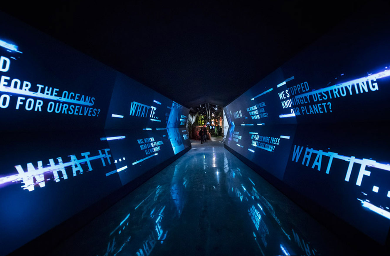 Leerer Medientunnel mit blauen Textprojektionen an Wänden, Boden und Decke – Urban Nation Biennale
