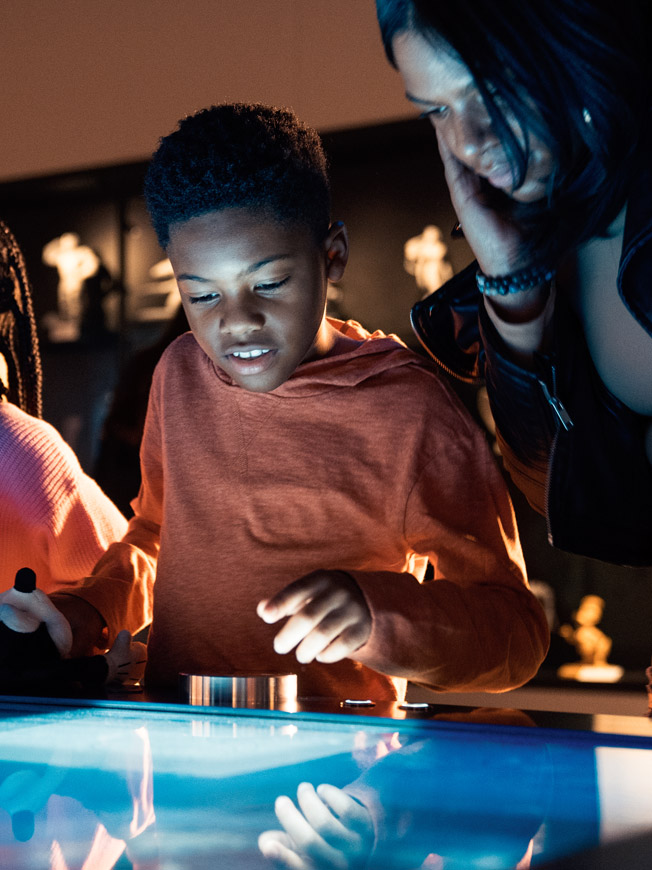 Besucher:innen an einem interaktiven Medientisch mit Charakter-Navigation in der Disney 100 Ausstellung – Medienkonzept und Interface-Design von cocurio