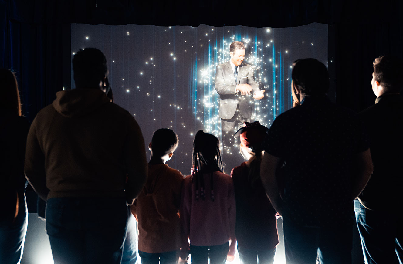 Besucher:innen erleben interaktive Hologramm-Inszenierung mit funkelnden Effekten auf der Magic Stage – Medienkonzept und Gestaltung von cocurio für Disney 100 Ausstellung