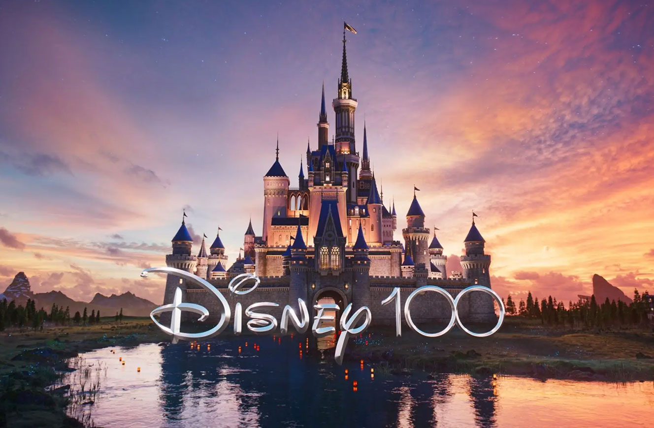 Disney 100 Jubiläumslogo vor ikonischem Märchenschloss bei Sonnenuntergang – Eröffnungsmotiv der internationalen Ausstellung mit Medienkonzept von cocurio